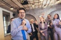 Business people having a karaoke party at the office, singing, dancing and having fun Royalty Free Stock Photo