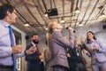 Business people having a karaoke party at the office, singing, dancing and having fun Royalty Free Stock Photo