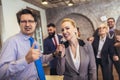 Business people having a karaoke party at the office, singing, dancing and having fun Royalty Free Stock Photo