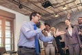 Business people having a karaoke party at the office, singing, dancing and having fun while Royalty Free Stock Photo