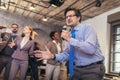 Business people having a karaoke party at the office, singing, dancing and having fun Royalty Free Stock Photo