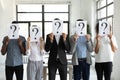 Business people hiding faces behind papers sheets with question marks. Royalty Free Stock Photo