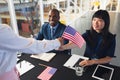 Business people holding an American flag at conference registration table Royalty Free Stock Photo