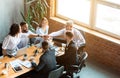 Business People Holding Hands Together Sitting At Desk In Office Royalty Free Stock Photo