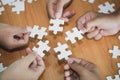 Business people Holding Jigsaw Puzzle, group of business people using a jigsaw puzzle to demonstrate the need to work in the same Royalty Free Stock Photo