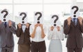 Business people holding question mark signs in office