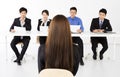 Business people interviewing young businesswoman in office