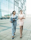 Business, people and lifestyle concept: two office workers standing together outdors near modern business building. Royalty Free Stock Photo