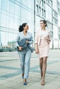 Business, people and lifestyle concept: two office workers standing together outdors near modern business building. Royalty Free Stock Photo