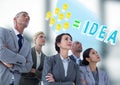 Business people looking at lightbulb doodle against blurry grey office Royalty Free Stock Photo