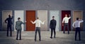 Business people looking to select the right door. Concept of confusion and competition Royalty Free Stock Photo