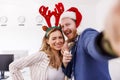 Business people making funny faces while taking selfies at the office Christmas party Royalty Free Stock Photo