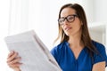 Happy woman in glasses reading newspaper at office Royalty Free Stock Photo