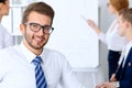 Business people at meeting in office. Focus at cheerful smiling bearded man wearing glasses. Conference, corporate Royalty Free Stock Photo