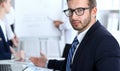 Business people at meeting in office. Focus at cheerful smiling bearded man wearing glasses. Conference, corporate Royalty Free Stock Photo