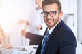 Business people at meeting in office. Focus at cheerful smiling bearded man wearing glasses. Conference, corporate Royalty Free Stock Photo