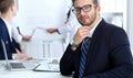 Business people at meeting in office. Focus at cheerful smiling bearded man wearing glasses. Conference, corporate Royalty Free Stock Photo