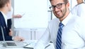 Business people at meeting in office. Focus at cheerful smiling bearded man wearing glasses. Conference, corporate Royalty Free Stock Photo