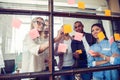 Business people meeting at office and use post it notes to share idea. Brainstorming concept. Sticky note on glass wall Royalty Free Stock Photo