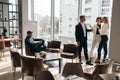 Business people meeting, talking while standing in front of the window