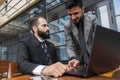 business people meets outdoors. Two men are using a laptop. Working break. Team and business support. Collaboration and Royalty Free Stock Photo