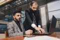 business people meets outdoors. Two men are using a laptop. Working break. Team and business support. Collaboration and Royalty Free Stock Photo