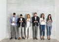 Business people with mobile phone standing by the wall Royalty Free Stock Photo