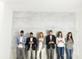 Business people with mobile phone standing by the wall Royalty Free Stock Photo