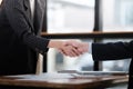 Business people in office suits standing and shaking hands, close-up. Business communication concept. Handshake and Royalty Free Stock Photo