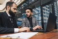 Business people outdoor meeting. A group of business people meet outdoors. Two men are using a laptop. Working break Royalty Free Stock Photo