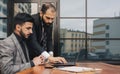 Business people outdoor meeting. A group of business people meet outdoors. Two men are using a laptop. Working break Royalty Free Stock Photo