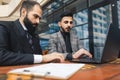 Business people outdoor meeting. A group of business people meet outdoors. Two men are using a laptop. Working break Royalty Free Stock Photo