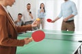 Business people playing ping pong in office, focus on tennis racket. Space for text Royalty Free Stock Photo