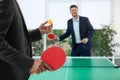 Business people playing ping pong in office, focus on racket Royalty Free Stock Photo