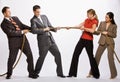 Business people playing tug-of-war