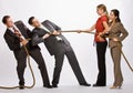 Business people playing tug-of-war