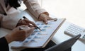 Business people pointing financial data graph on the table in the meeting room