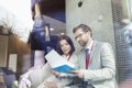 Business people reading document while sitting in convention center Royalty Free Stock Photo