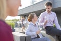 Mature businessman toasting wineglass with colleagues on rooftop during success party