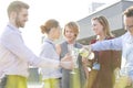 Mature businessman toasting wineglass during success party on rooftop