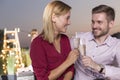 Portrait of smiling young businesswoman holding wineglass while standing against colleagues at rooftop during success party Royalty Free Stock Photo