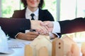 Business people shake hands while discuss and sign contract in meeting desk with smiling businesswoman in black suit blurred Royalty Free Stock Photo