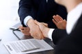 Business people shaking hands after contract signing at the glass desk in modern office. Unknown businessman, male