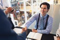 Business people shaking hands with each other while checking in at conference registration table Royalty Free Stock Photo