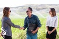 Business people shaking hands in a green field with agriculture irrigation system Royalty Free Stock Photo