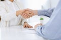 Business people shaking hands at meeting or negotiation. Businessman and woman handshake at office while sitting at the Royalty Free Stock Photo