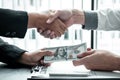 Business people shaking hands with money in hands from their partner to give success the deal contract in a corruption scam, Royalty Free Stock Photo