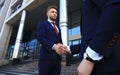 Business people shaking hands outside modern office building. Royalty Free Stock Photo