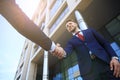 Business people shaking hands outside modern office building. Royalty Free Stock Photo