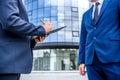 Business people signing contract near skyscraper outdoors Royalty Free Stock Photo